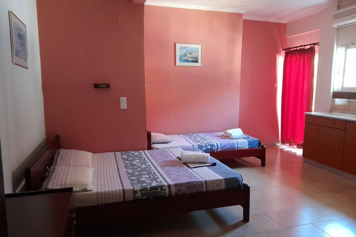 Spavaći deo studija u Vili Thomas u Nei Poriju sa više kreveta i kuhinjskim delom