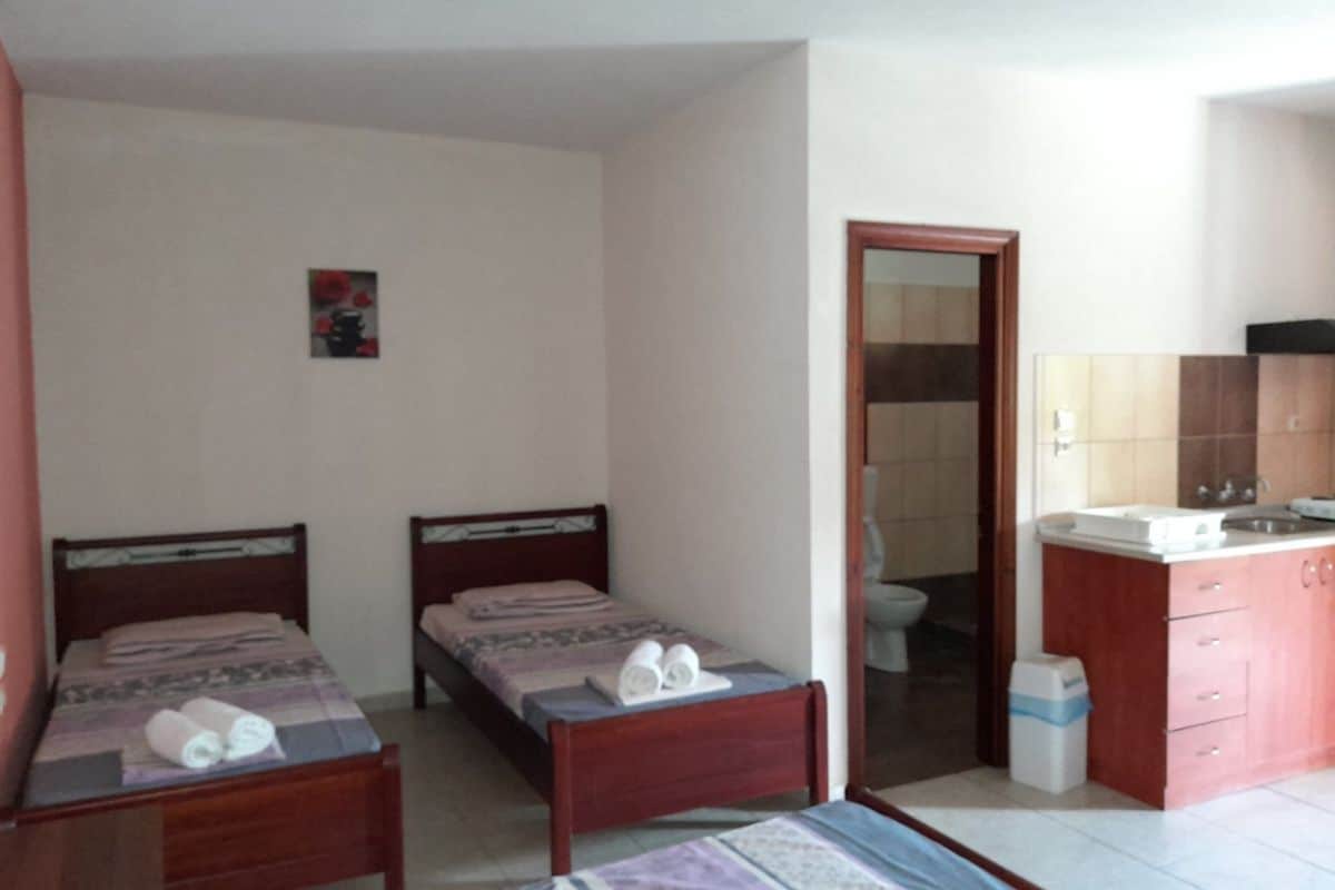 Spavaći deo studija u Vili Thomas u Nei Poriju sa više kreveta i kuhinjskim delom