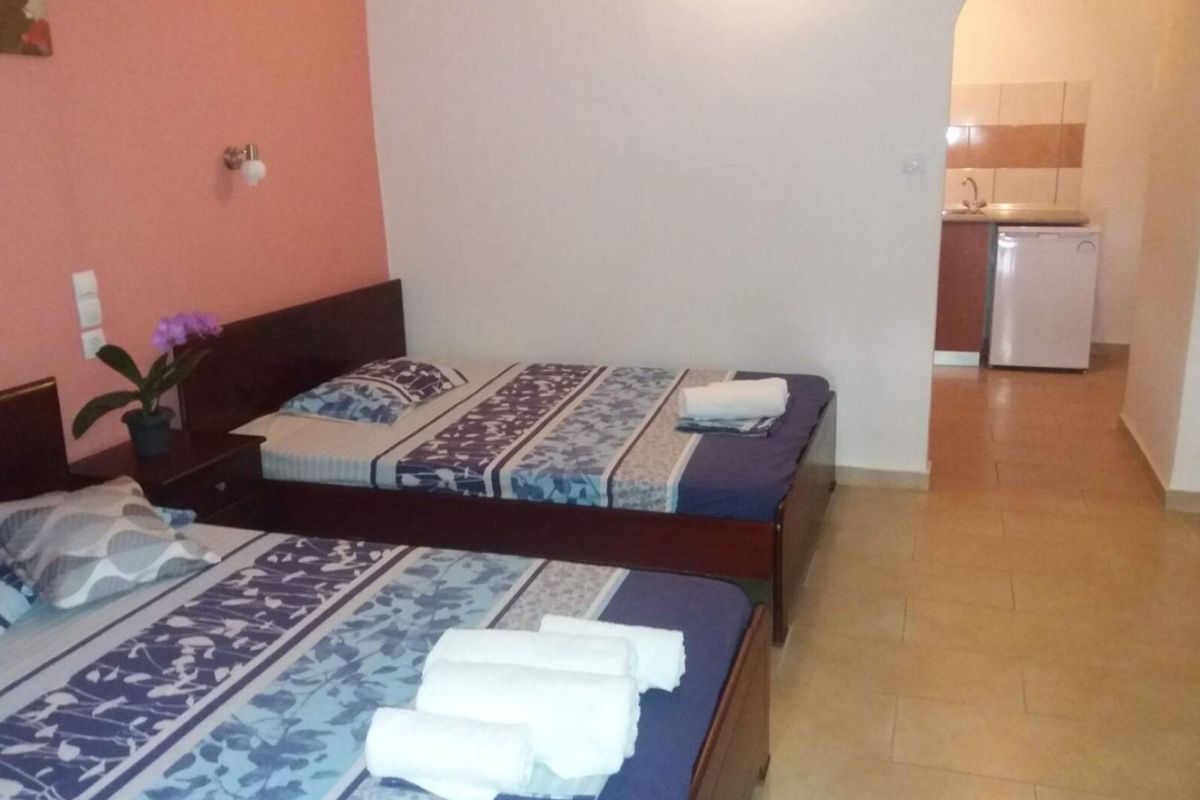 Spavaći deo studija u Vili Thomas u Nei Poriju sa više kreveta i kuhinjskim delom