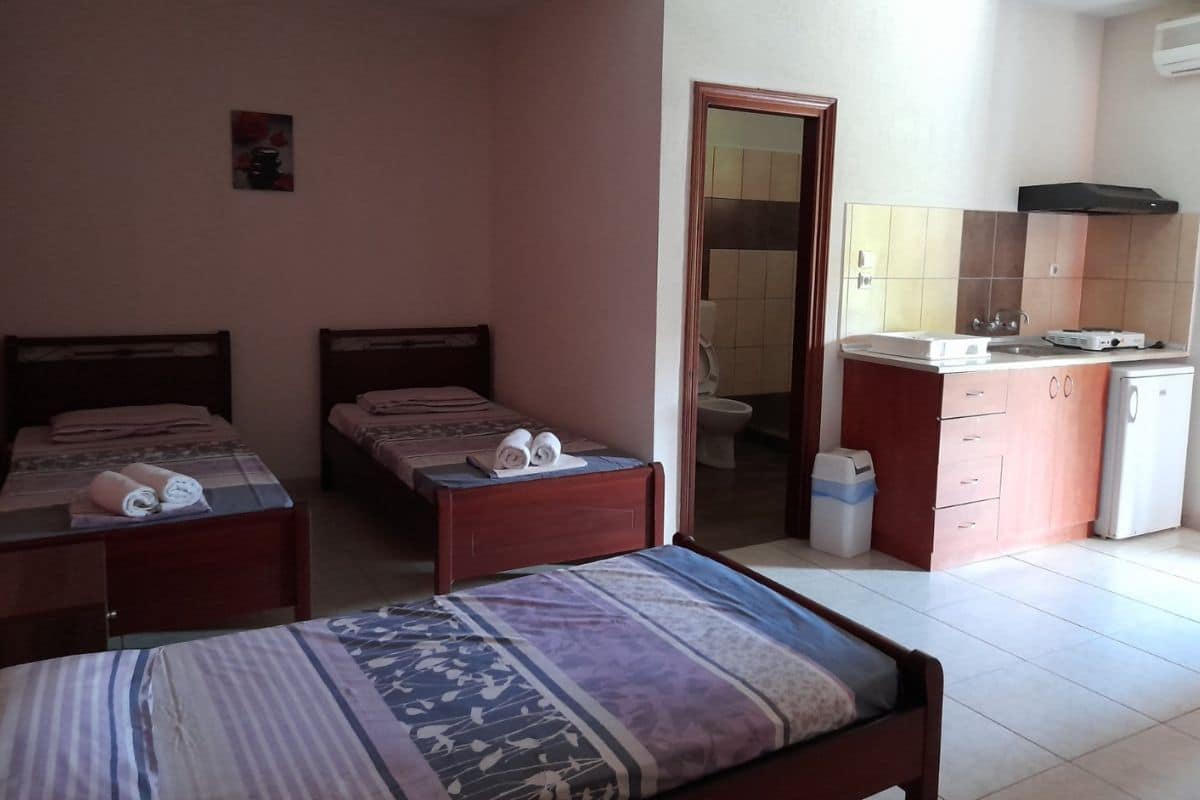 Spavaći deo studija u Vili Thomas u Nei Poriju sa više kreveta i kuhinjskim delom