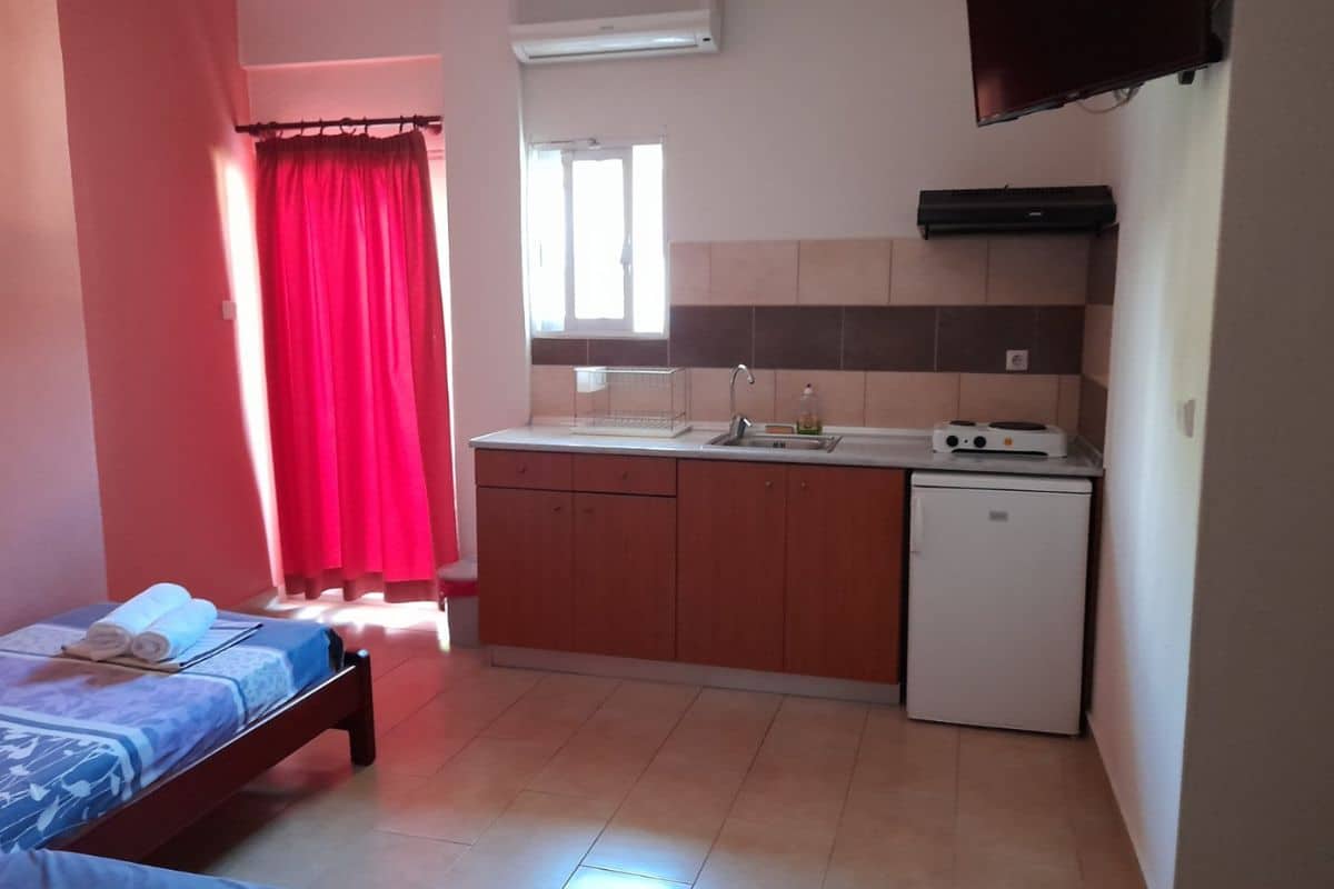 Spavaći deo studija u Vili Thomas u Nei Poriju sa više kreveta i kuhinjskim delom